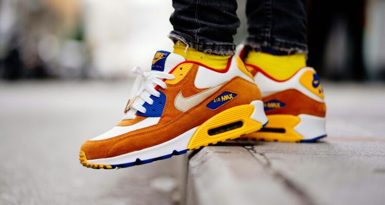 close-up photography of person wears brown-and-white Nike Air Max